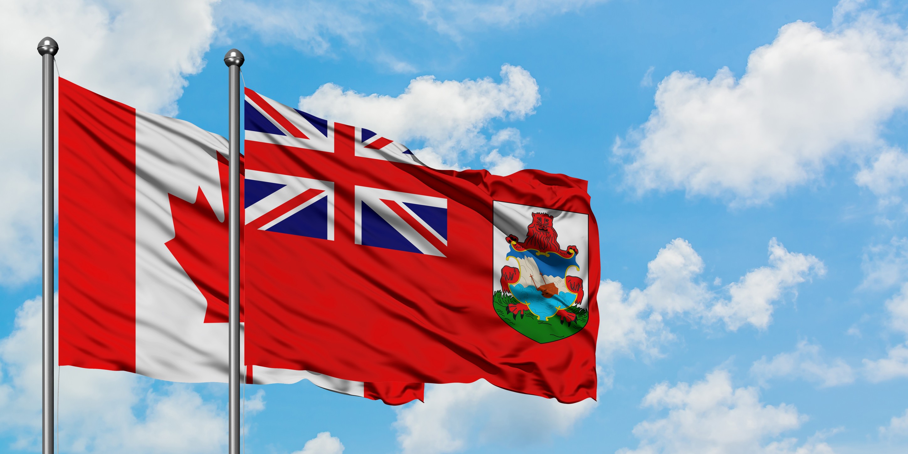Canada And Bermuda Flag Waving In The Wind