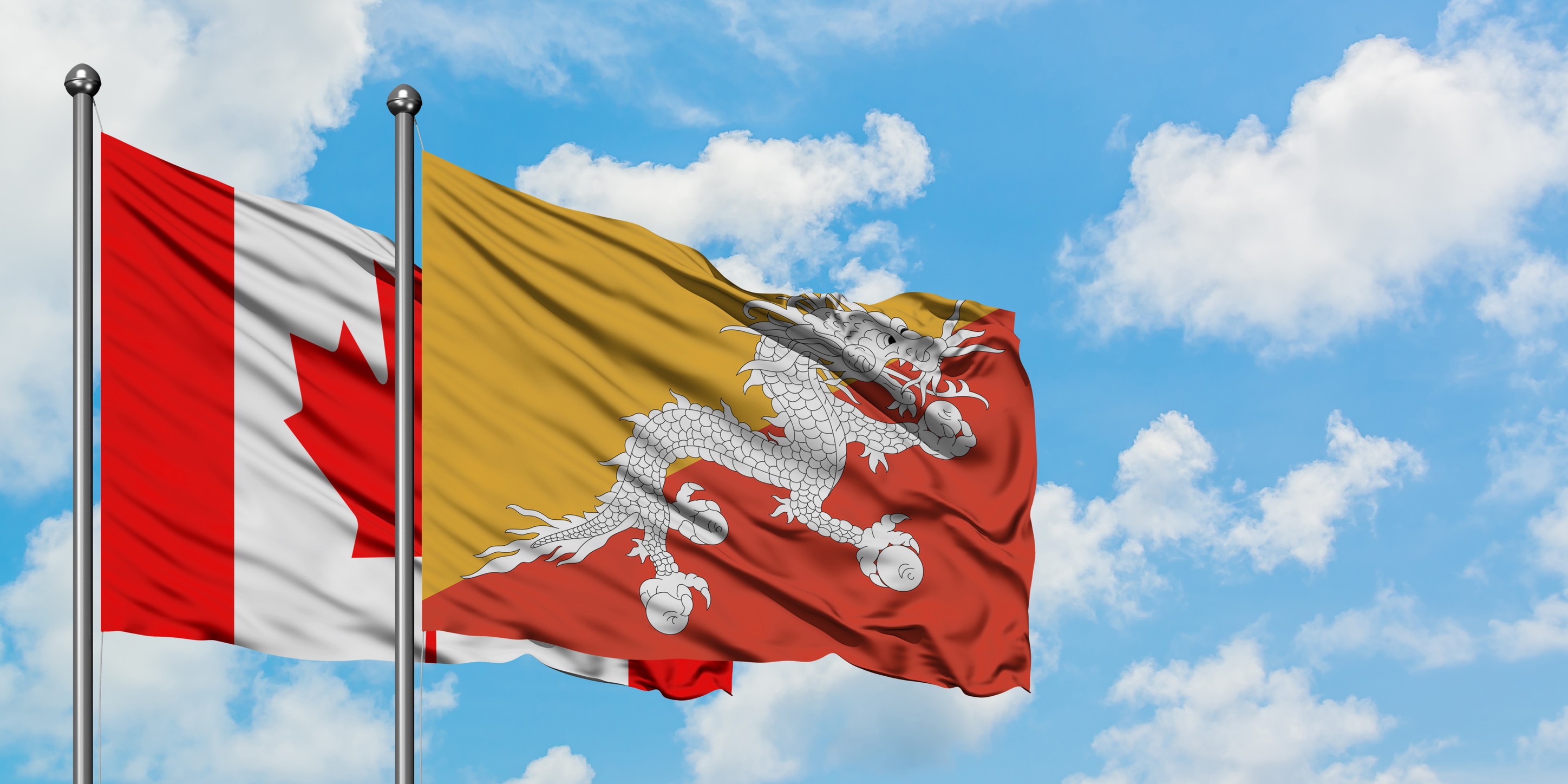 Canada And Bhutan Flag Waving In The Wind