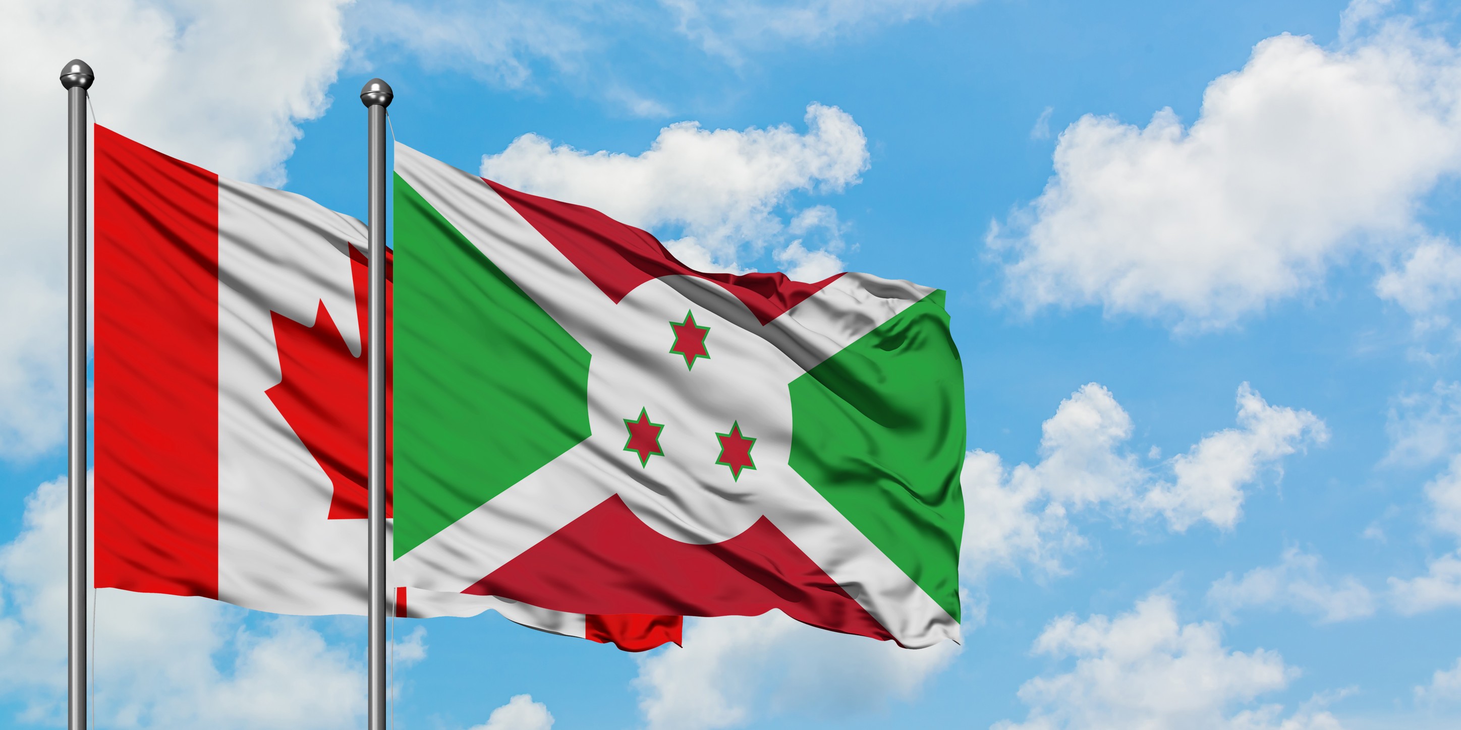 Canada And Burundi Flag Waving In The Wind Against White
