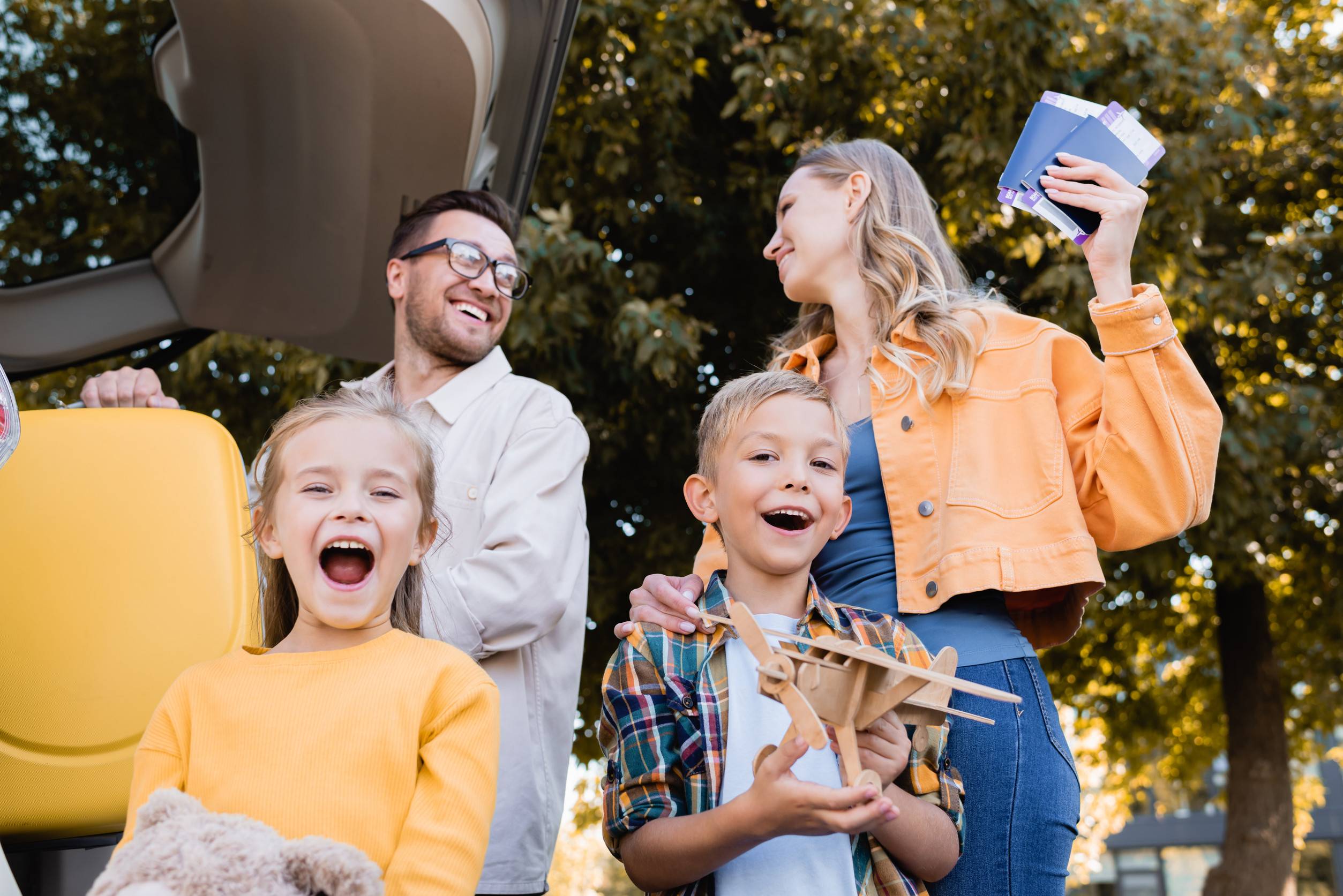 Cheerful Kids With Toys Standing Near Parents