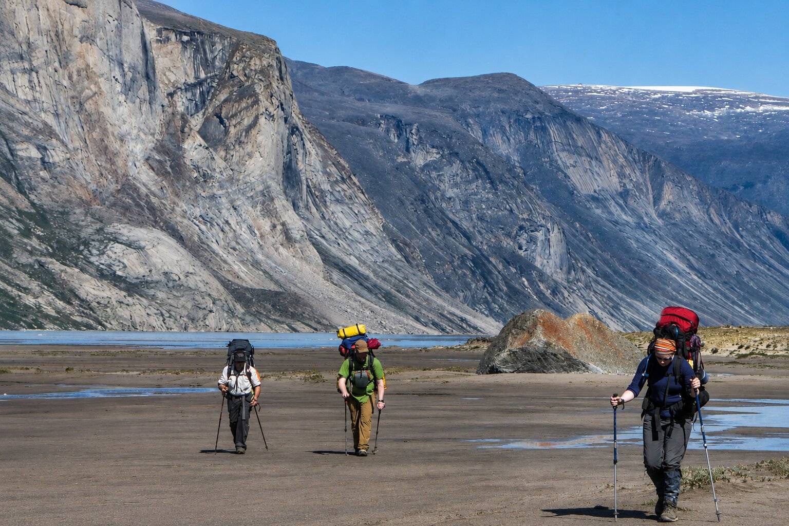 Hikers walking through a dried river in Auyuittuq National Park