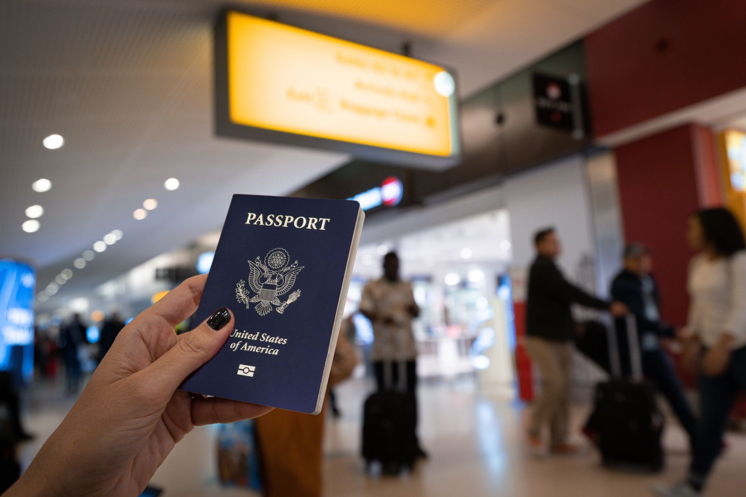 close up of woman holding an united states passport at the airport