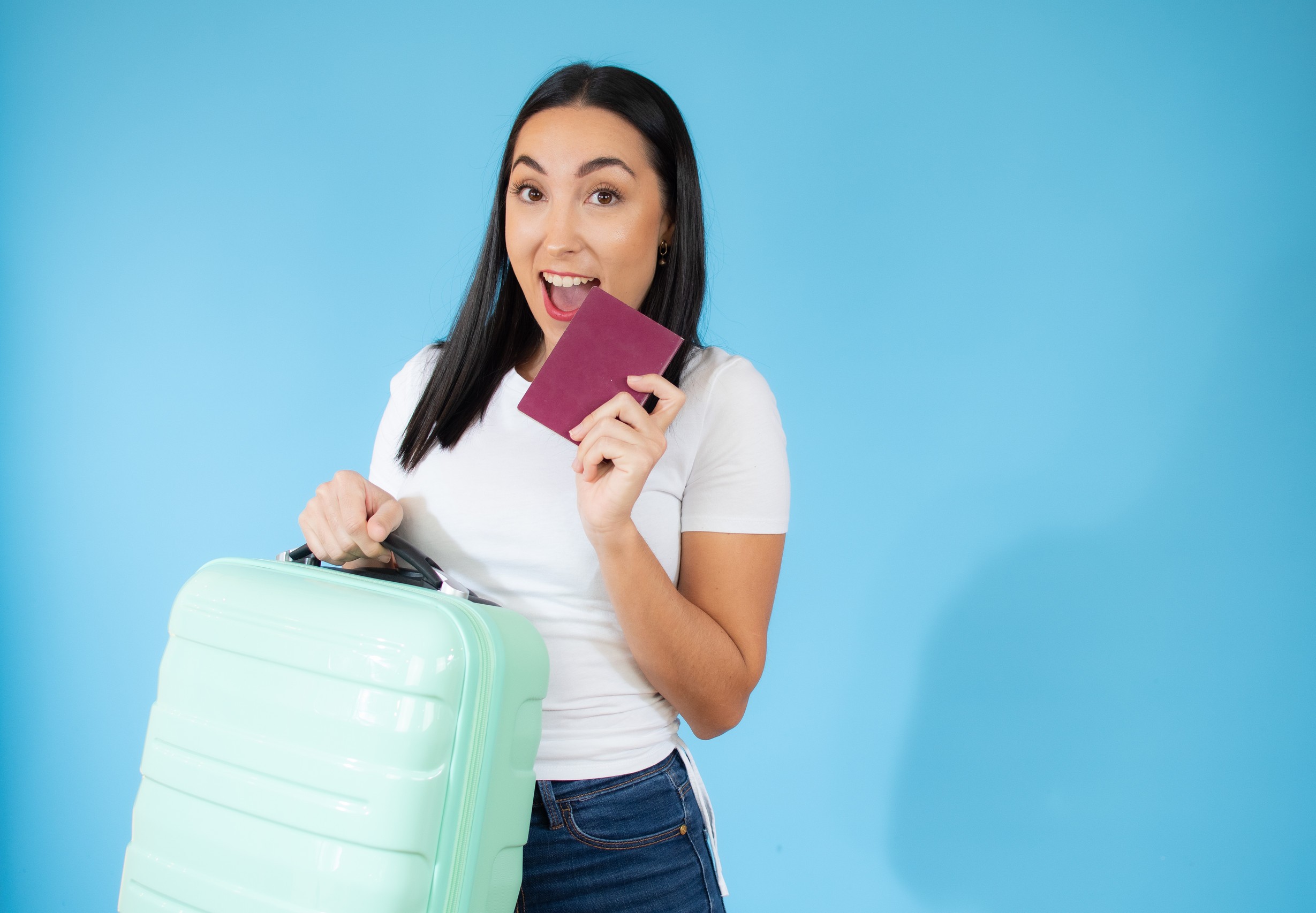 concept of travel happy woman with suitcase and passport