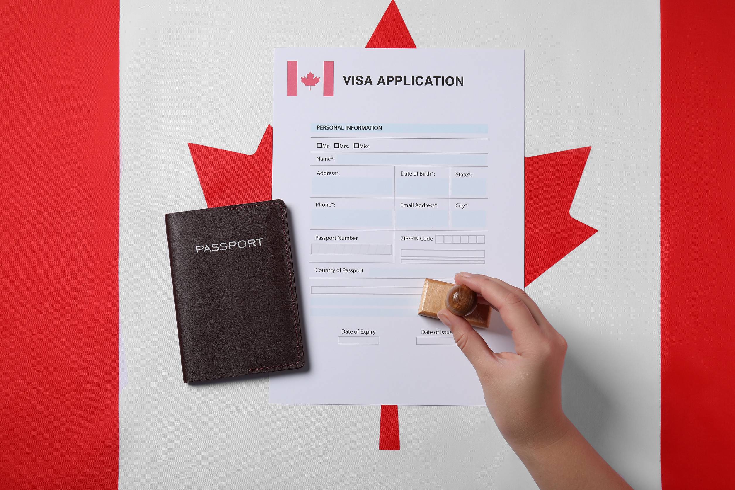 immigration to canada woman stamping application form on flag top