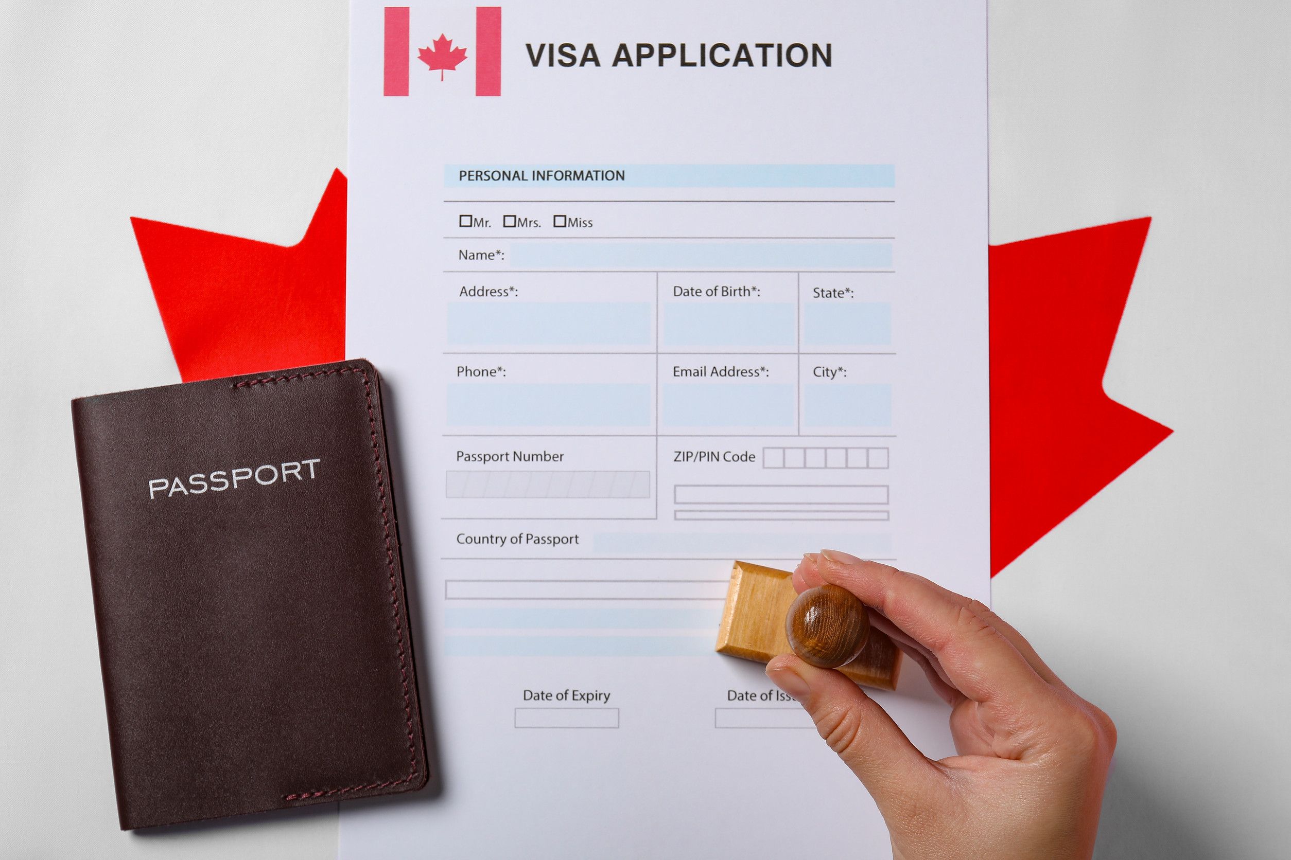 immigration to canada woman stamping visa application form on flag