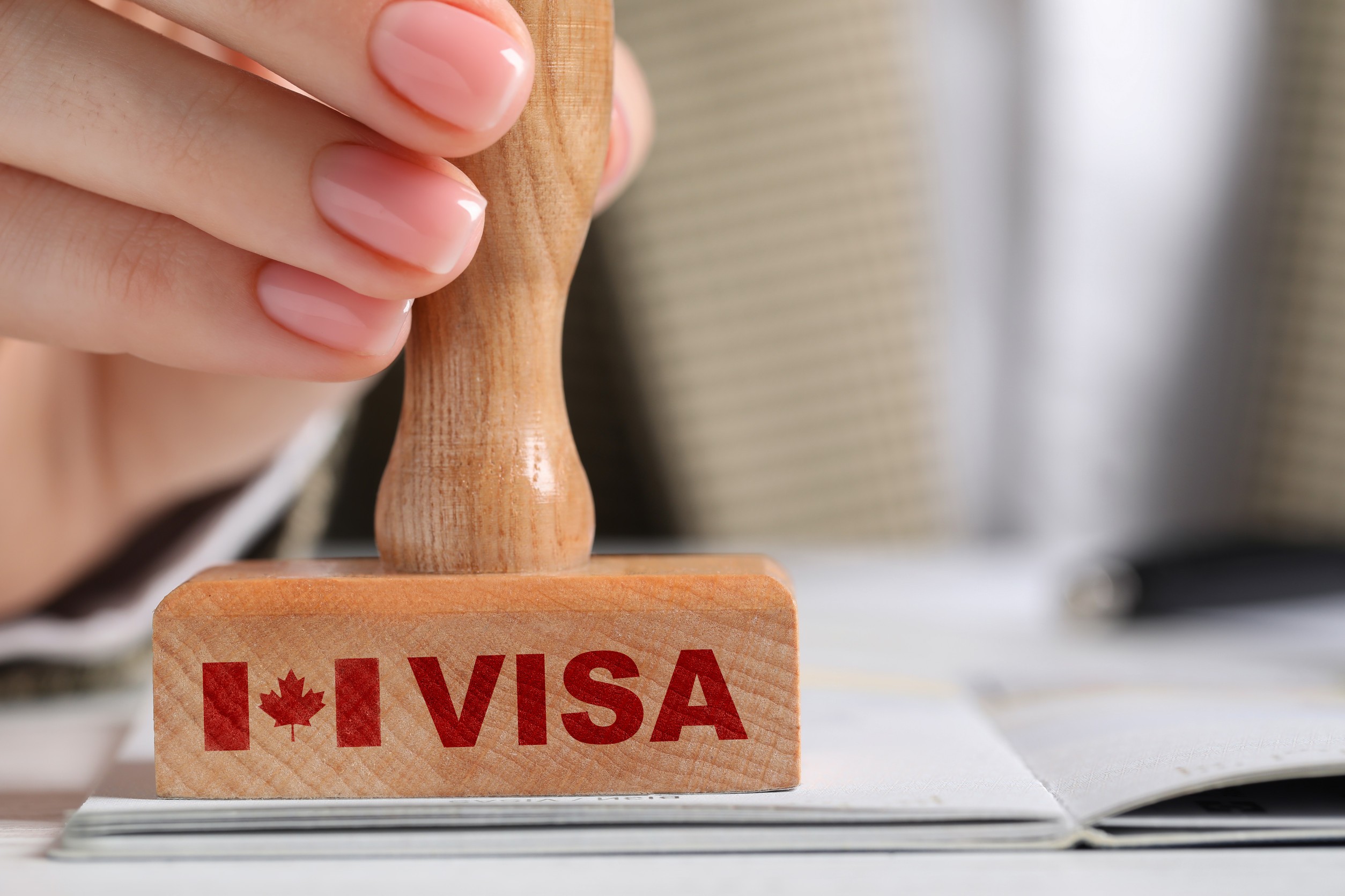 woman stamping document on white wooden table closeup visa for canada