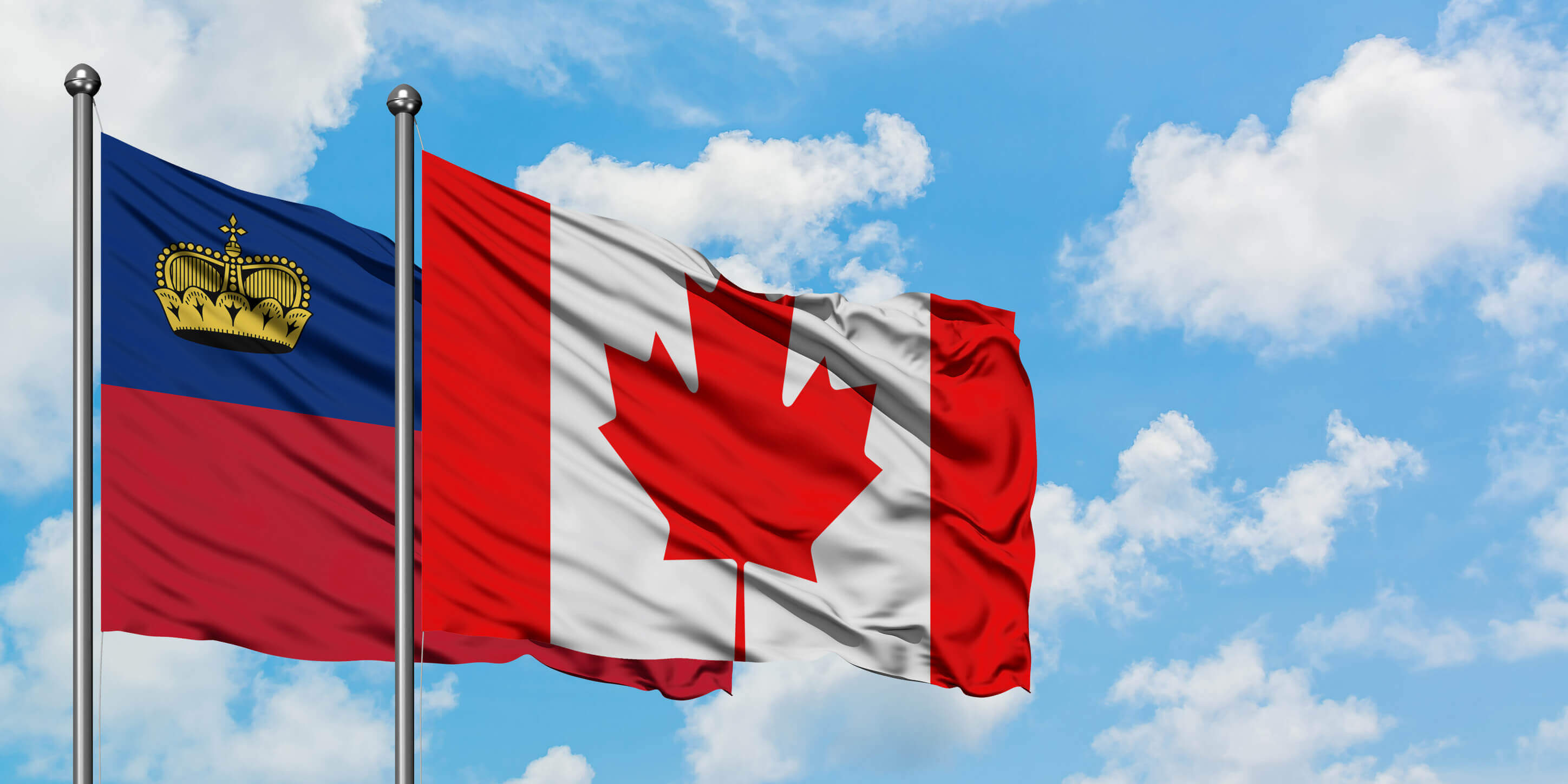Liechtenstein And Canada Flag Waving In The Wind Against White Cloudy