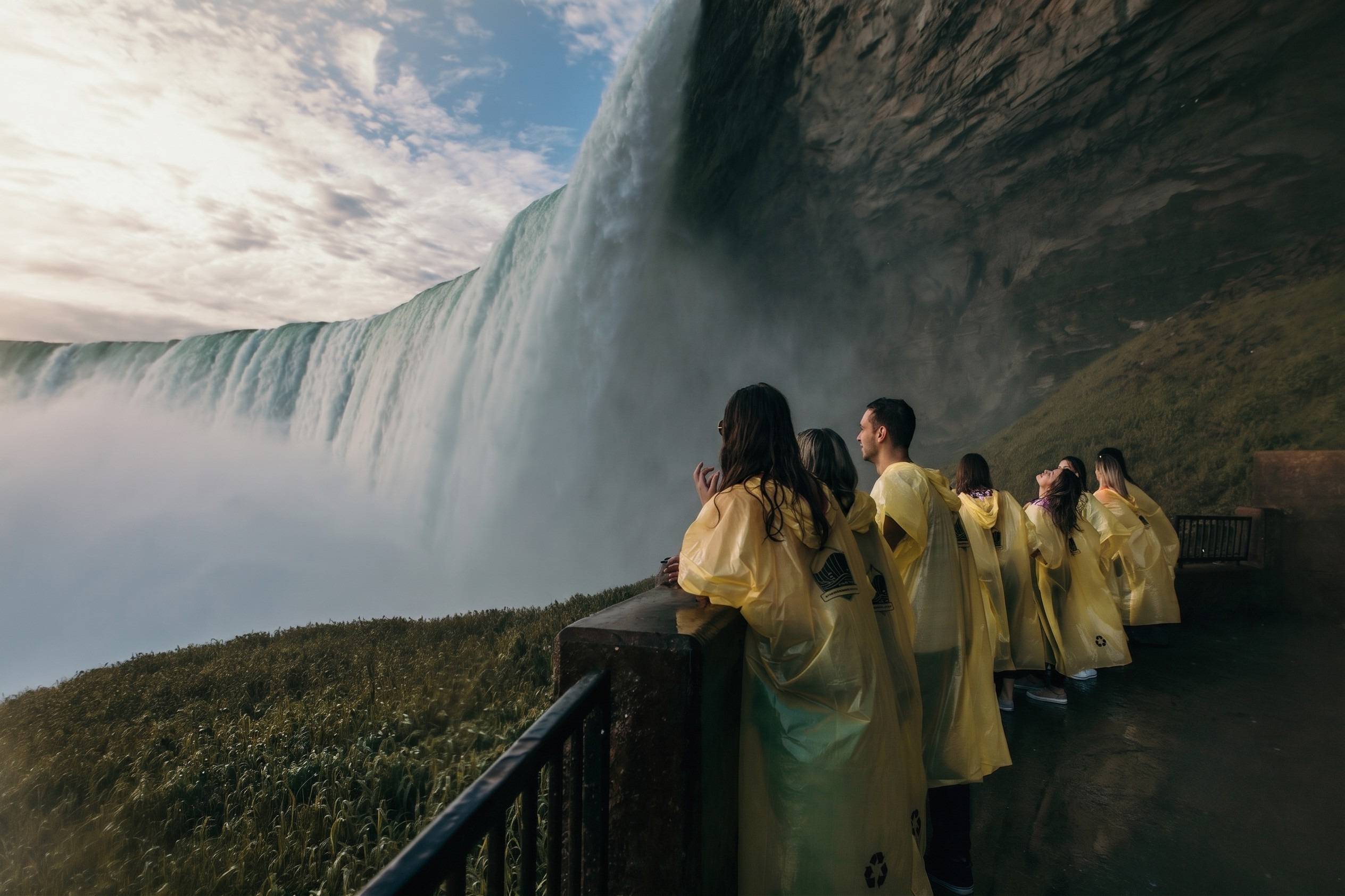 People Standing Behind One Of The Niagara Waterfalls