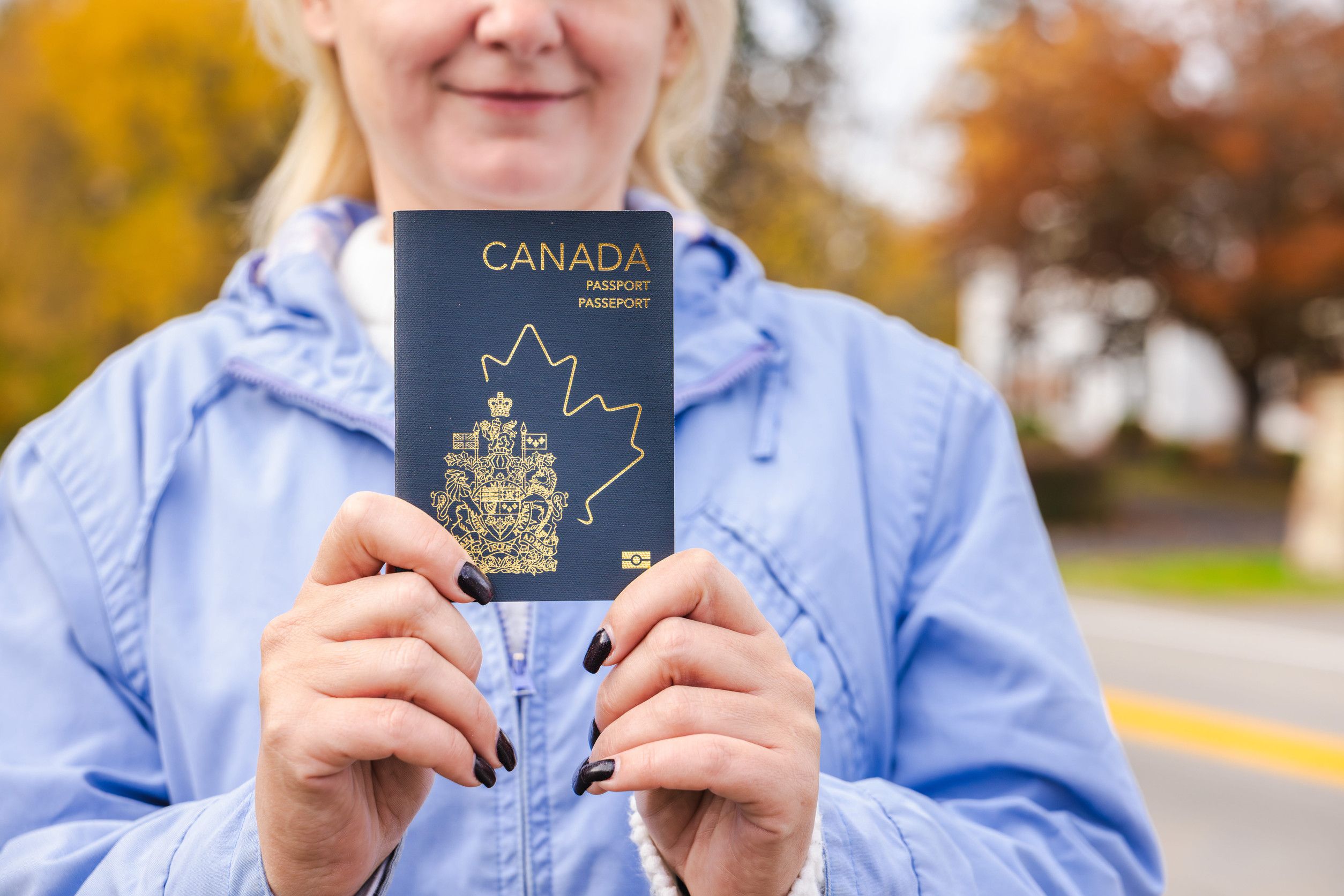 Woman Outdoors Holding A Canadian Passport